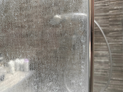closeup of mineral builup on shower door
