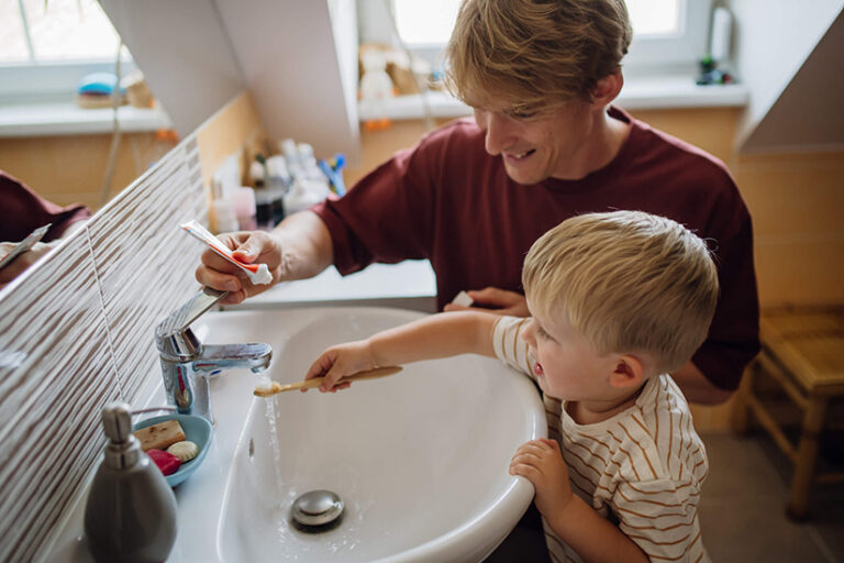 Father and son over sink