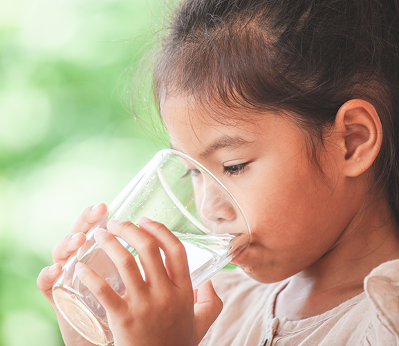 girl drinking from water glass