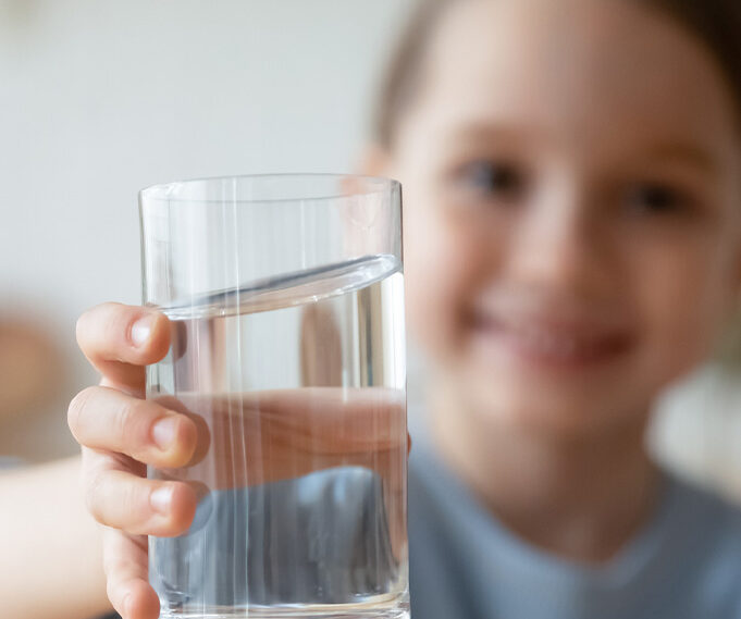 child holding clean glass of water